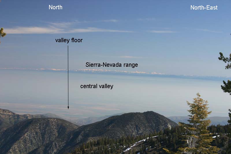 This 55 mm image was taken from the summit of Mt. Pinos at elevation 8,831 ft. (2692 meters). The vista shows a good portion of California's central valley as well as the Sierra-Nevada range (roughly 100 to 200 miles distant and spanning North to North-East). Looking from binoculars (on a clear day like below) allows one to see individual peaks in the Sierra-Nevadas, such as Mt. Whitney (image below this).