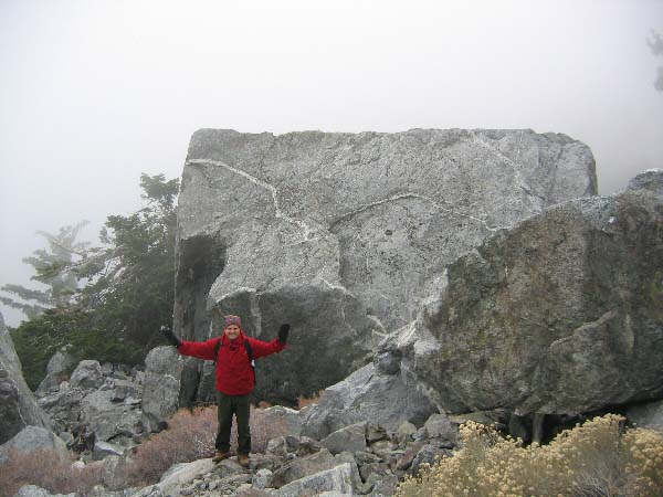 image: 8500 feet during ascent: Dominick dwarfed by a giant boulder. Some of the boulders have a man-made geometeric look. They were all formed through natural, geologic processes