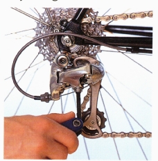 Shift the chain onto the biggest chainring and smallest cog, then undo the cable-fixing clamp so that the cable hangs free. 