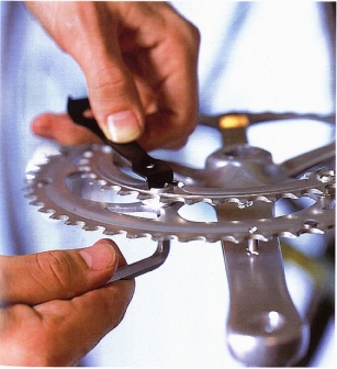 Remove the chainring with a 5mm Allen key on one side and a chainring bolt peg wrench to hold the bolt on the other. You can do this without taking the crankset off the axle, but you must remove it if you are working on the inner rings of some triple cranksets.