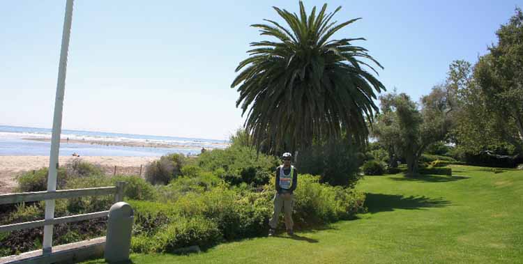 this image shows: Wide-angle view facing North-west. At Malibu Lagoon State Park; Adamson House lawn. Beach and lagoon can be seen to the left of me.