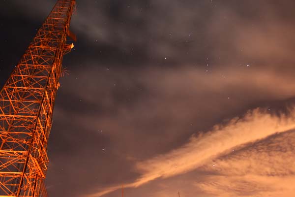 Same as above, this time with moving clouds. Rising Sirius and Orion consellations (right) juxteposed with communications tower (left)