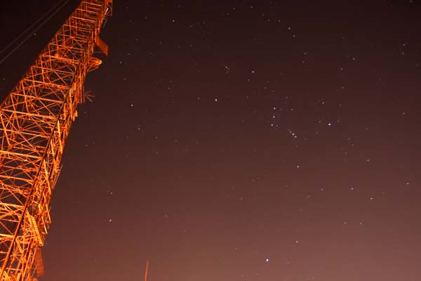 Rising Sirius and Orion consellations (right) juxteposed with communications tower (left)